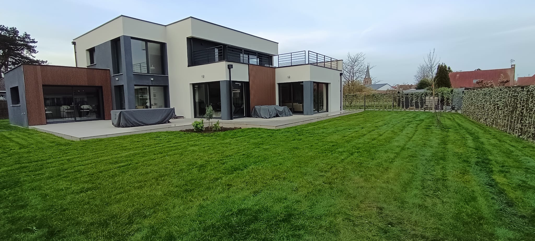 Aménagement extérieur à Lille : maison moderne avec terrasse et jardin paysager entretenu